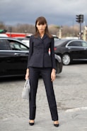 woman in black blazer and black pants standing on road during daytime