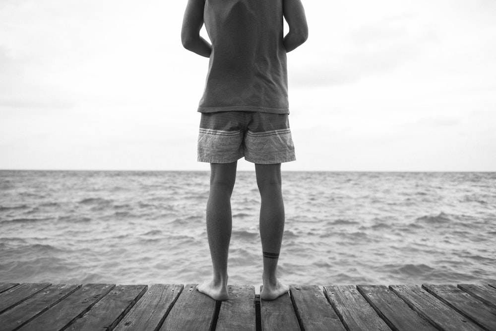 woman in white skirt standing on wooden dock