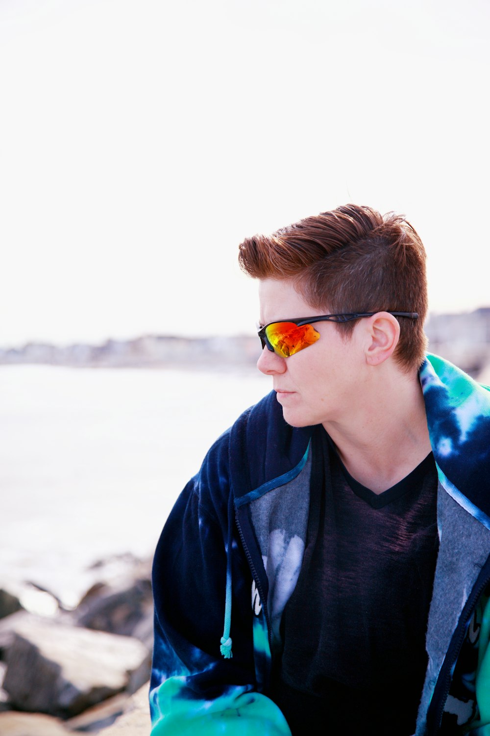 boy in blue and black jacket wearing yellow sunglasses
