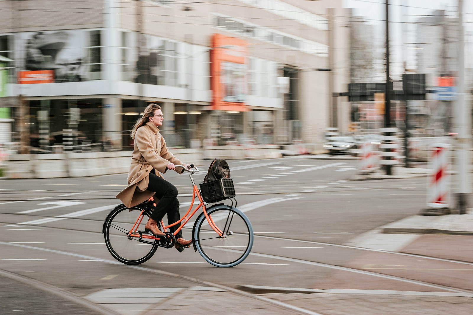 a woman riding her bicycle through an urban intersection