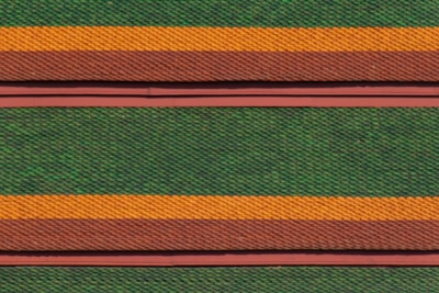 Rows of roof tiles are arranged in a detailed, repetitive pattern featuring alternating colors of green, orange, and brown. The tiles have a scale-like texture, creating a visually striking and textured appearance.