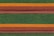 Rows of roof tiles are arranged in a detailed, repetitive pattern featuring alternating colors of green, orange, and brown. The tiles have a scale-like texture, creating a visually striking and textured appearance.