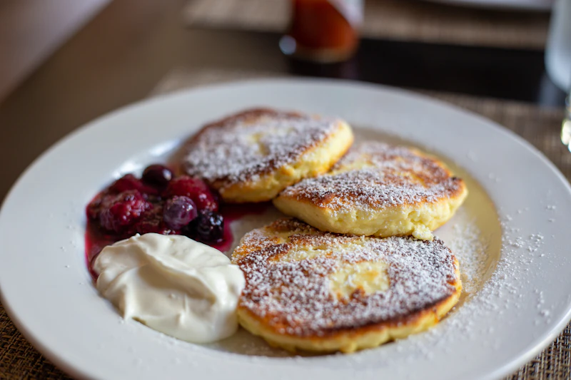 Golden Latvian potato pancakes topped with sour cream and chives