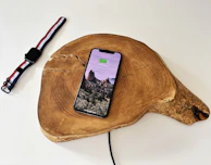 The iPhone 17 charging wirelessly on a MagSafe charger with battery optimization indicators on screen.