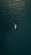 aerial view of person in white shirt riding on white boat on water during daytime