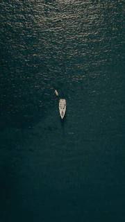 aerial view of person in white shirt riding on white boat on water during daytime
