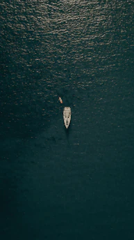 aerial view of person in white shirt riding on white boat on water during daytime
