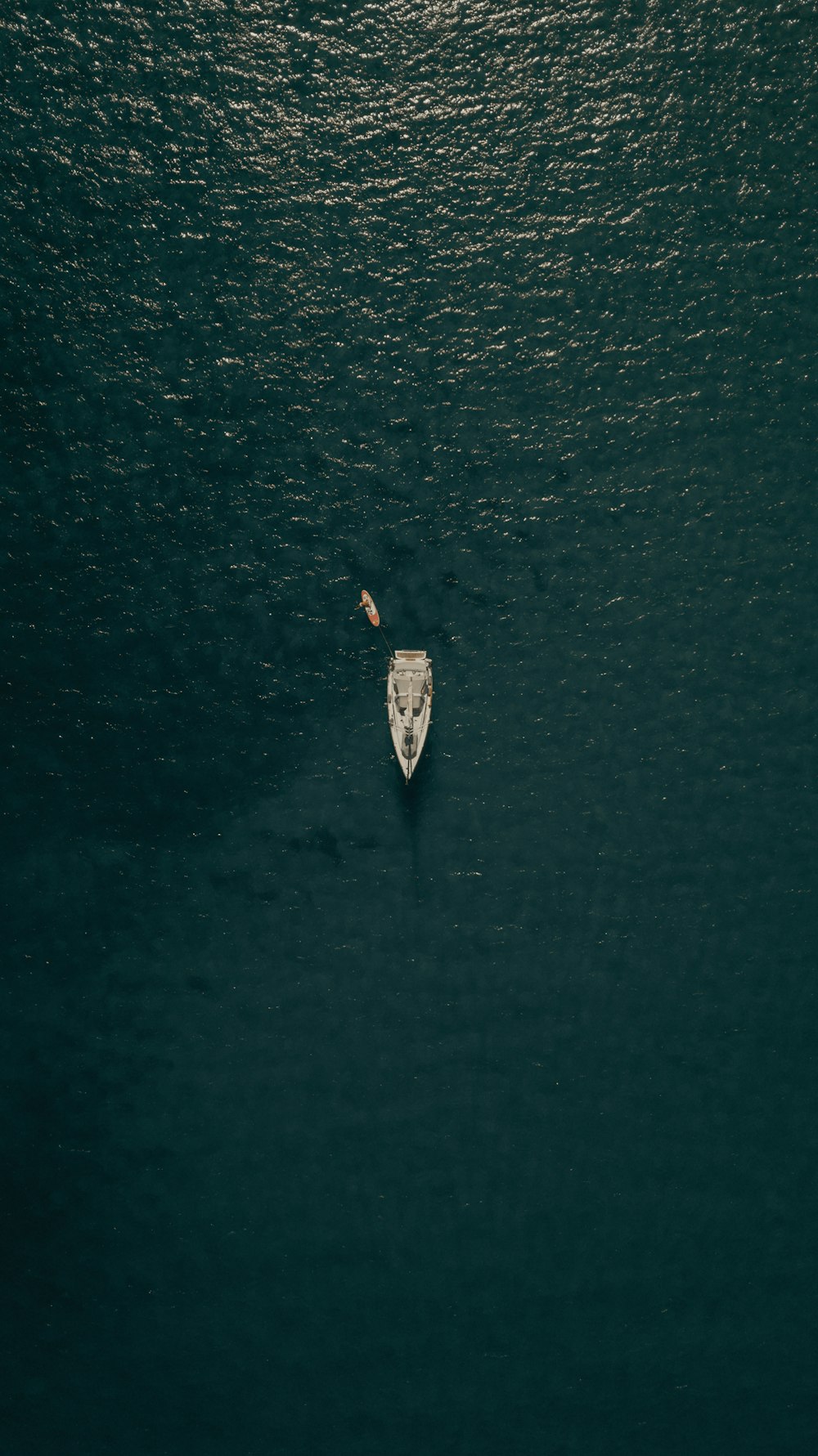 Vista aerea della persona in camicia bianca che cavalca sulla barca bianca sull'acqua durante il giorno