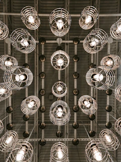 silver round pendant lamps turned on in grayscale photography