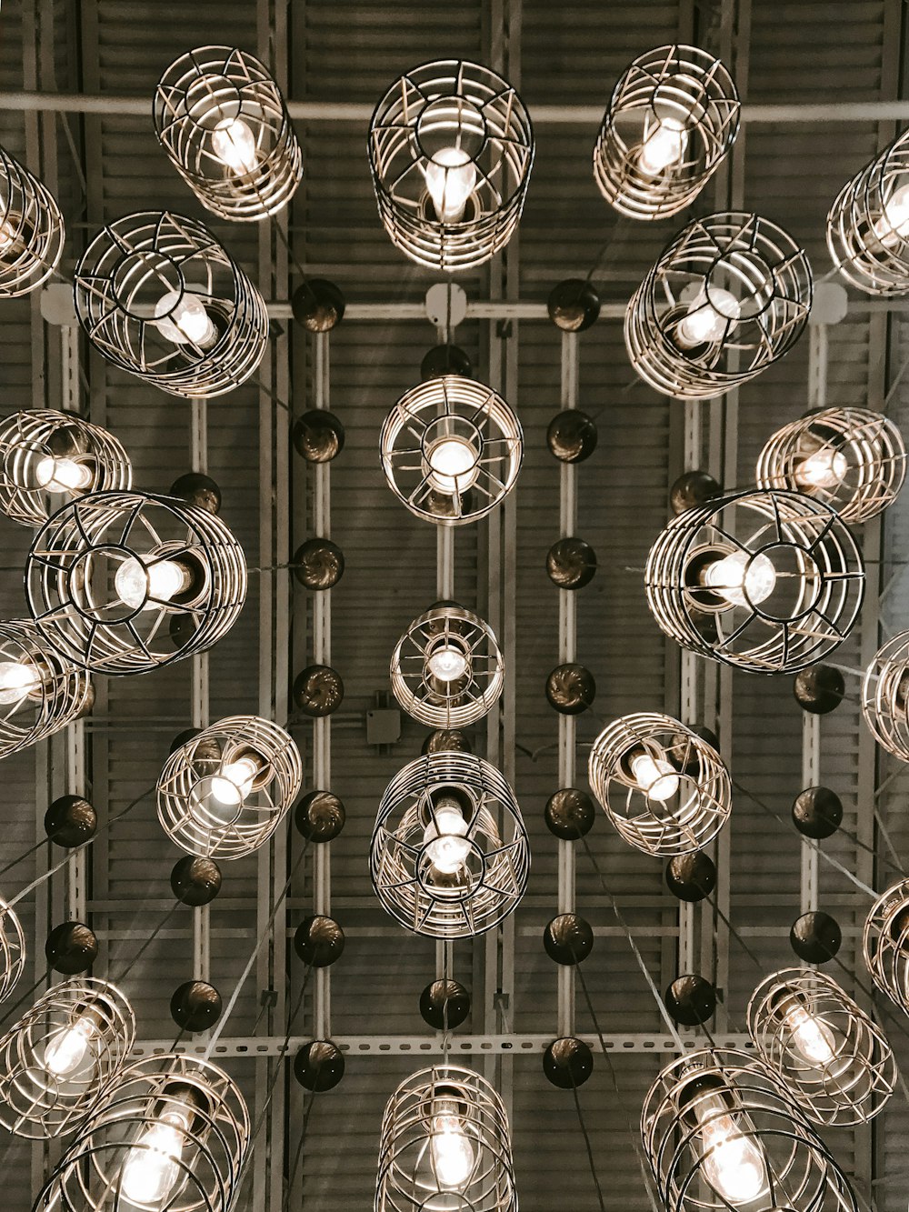 silver round pendant lamps turned on in grayscale photography