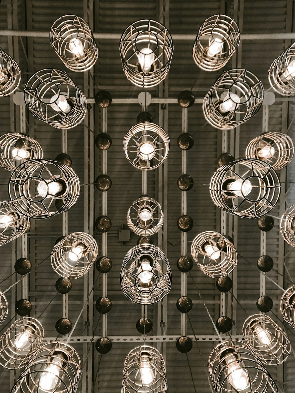Lampes suspendues rondes argentées allumées en photographie en niveaux de gris