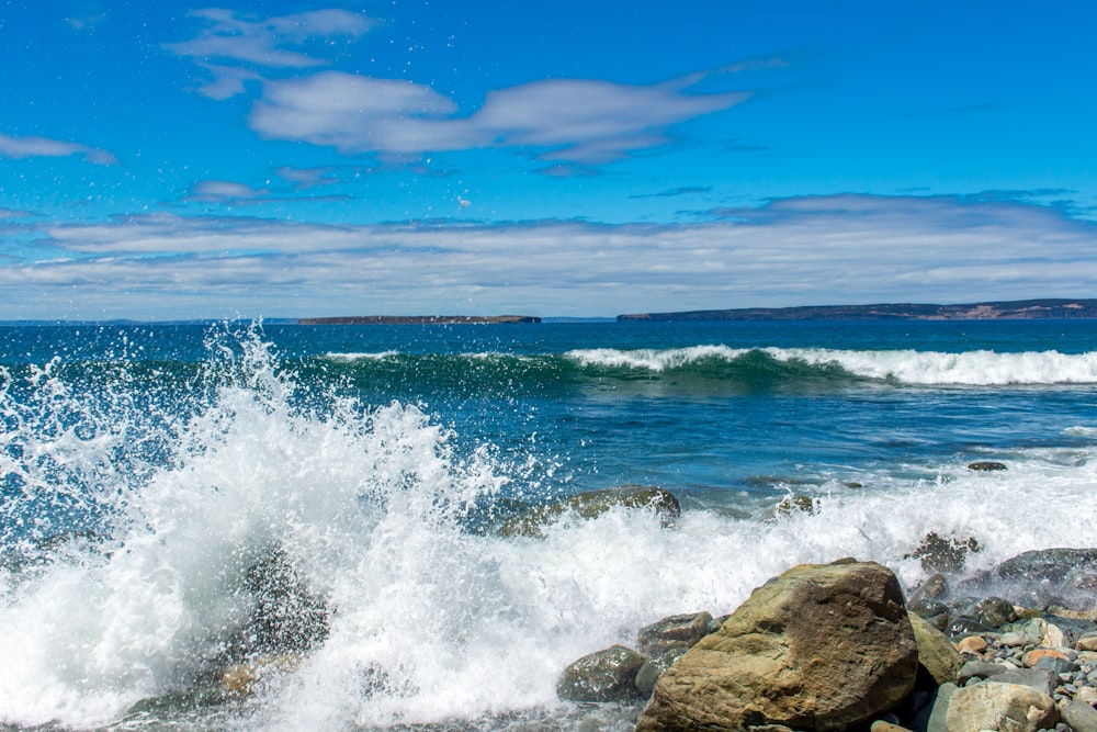 ocean waves crashing on rocks during daytime