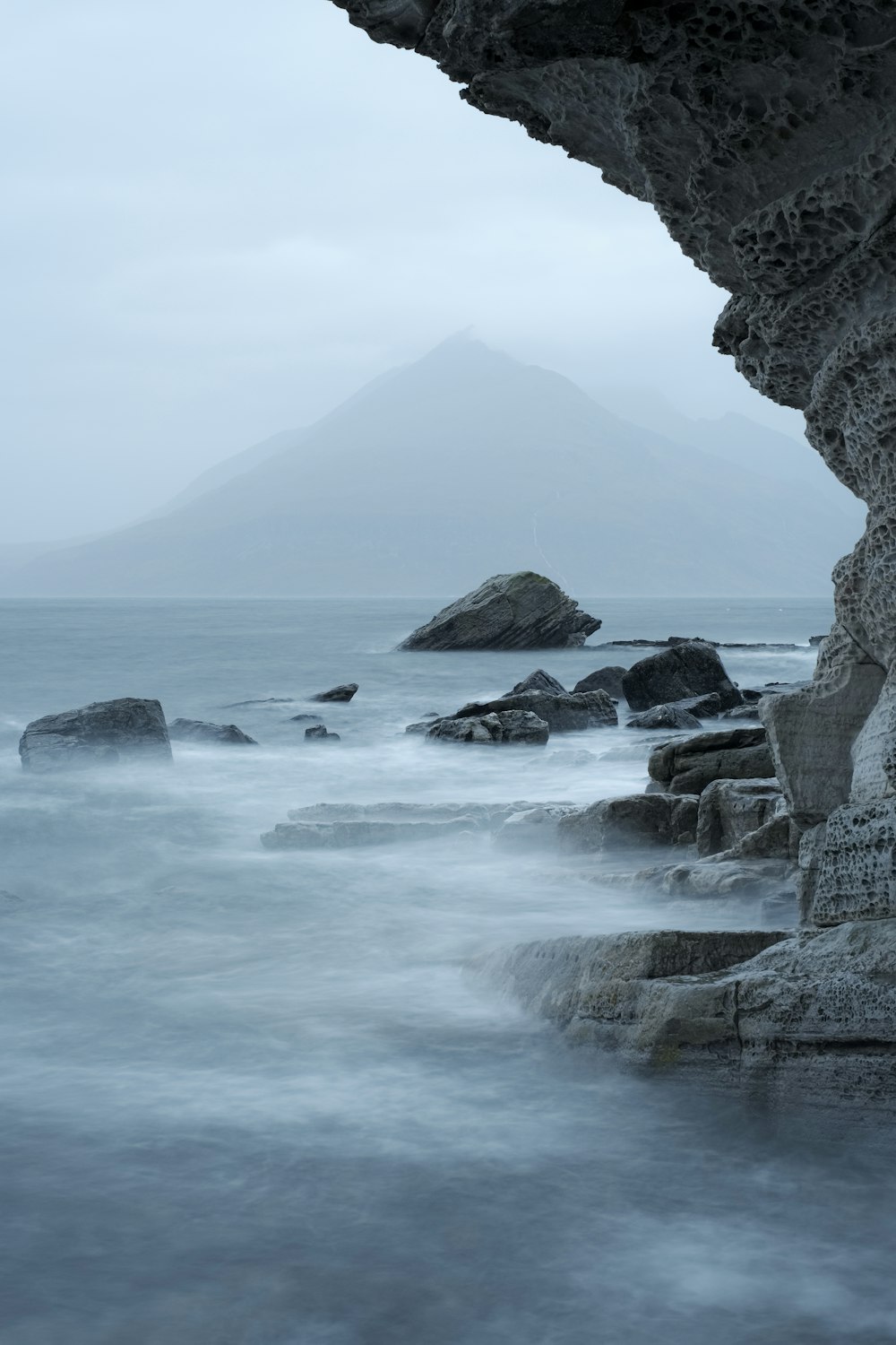 Montaña rocosa al lado del cuerpo de agua durante el día