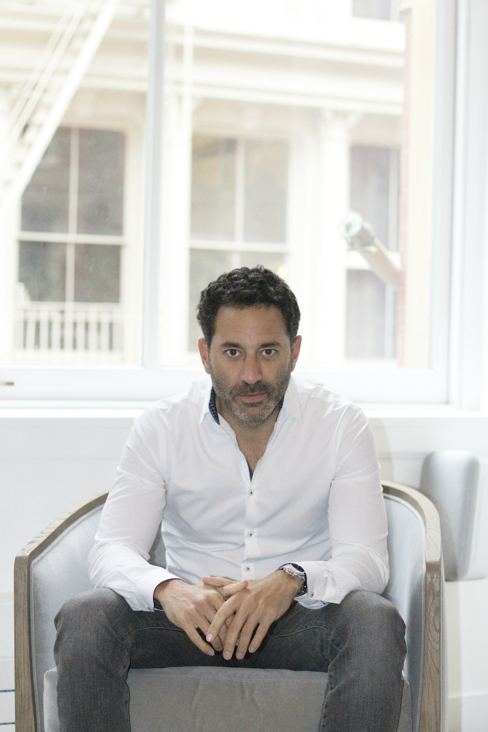 man in white dress shirt sitting on white chair