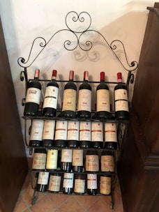 A sleek stainless steel wine rack holding several bottles in a cozy kitchen corner.