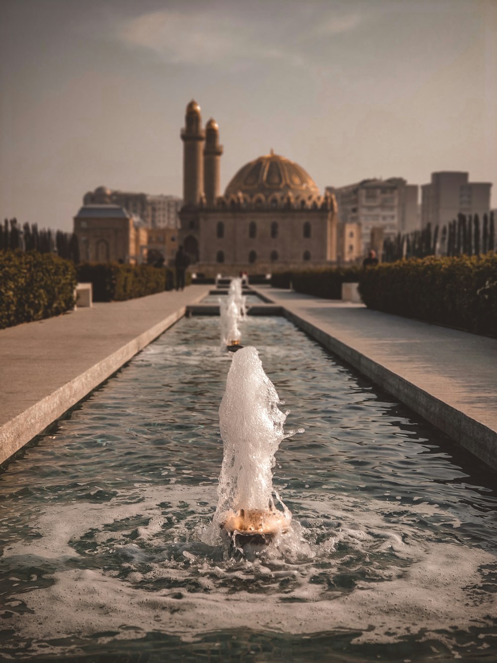 water fountain in front of brown dome building