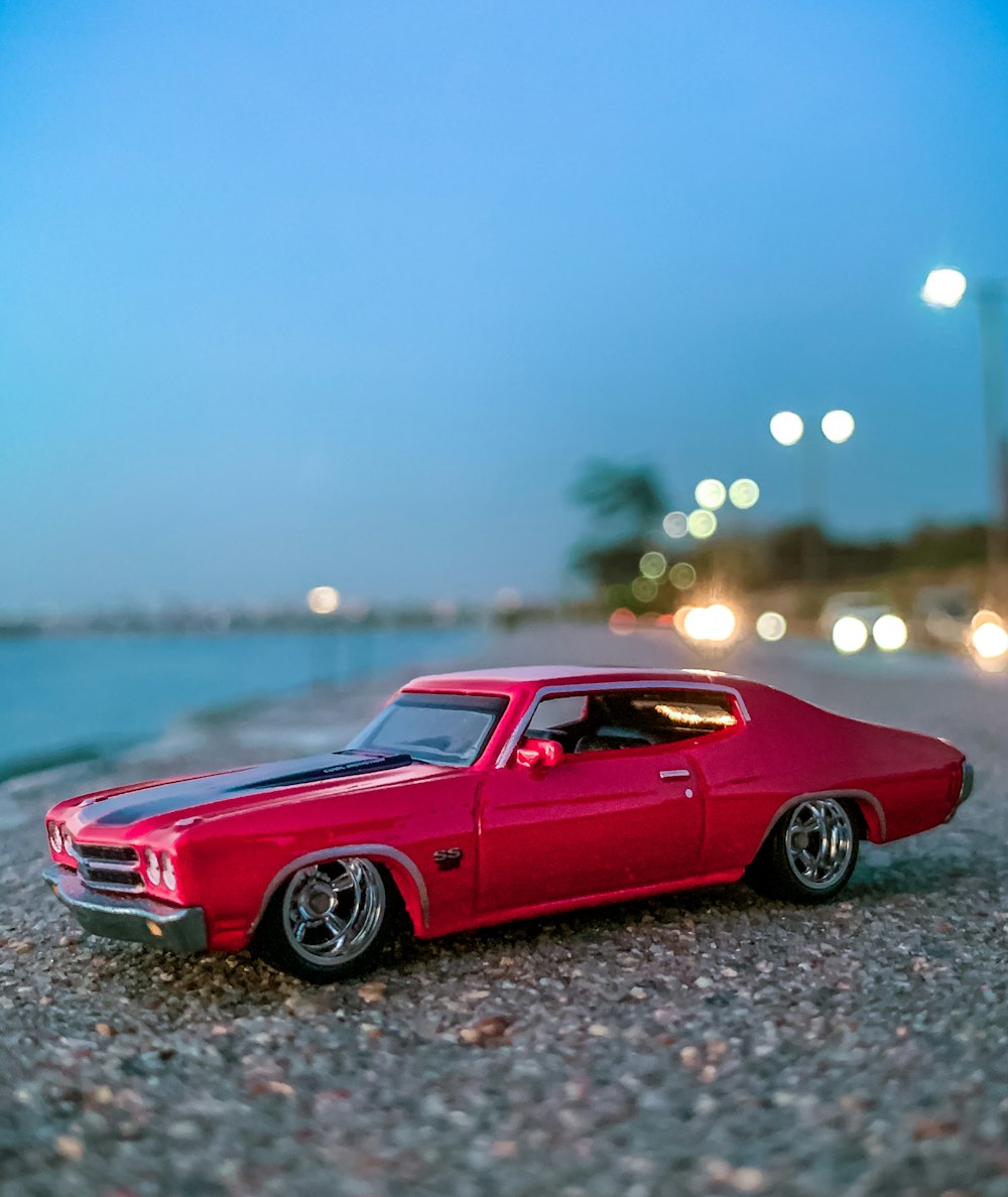 red chevrolet camaro on gray concrete road during daytime