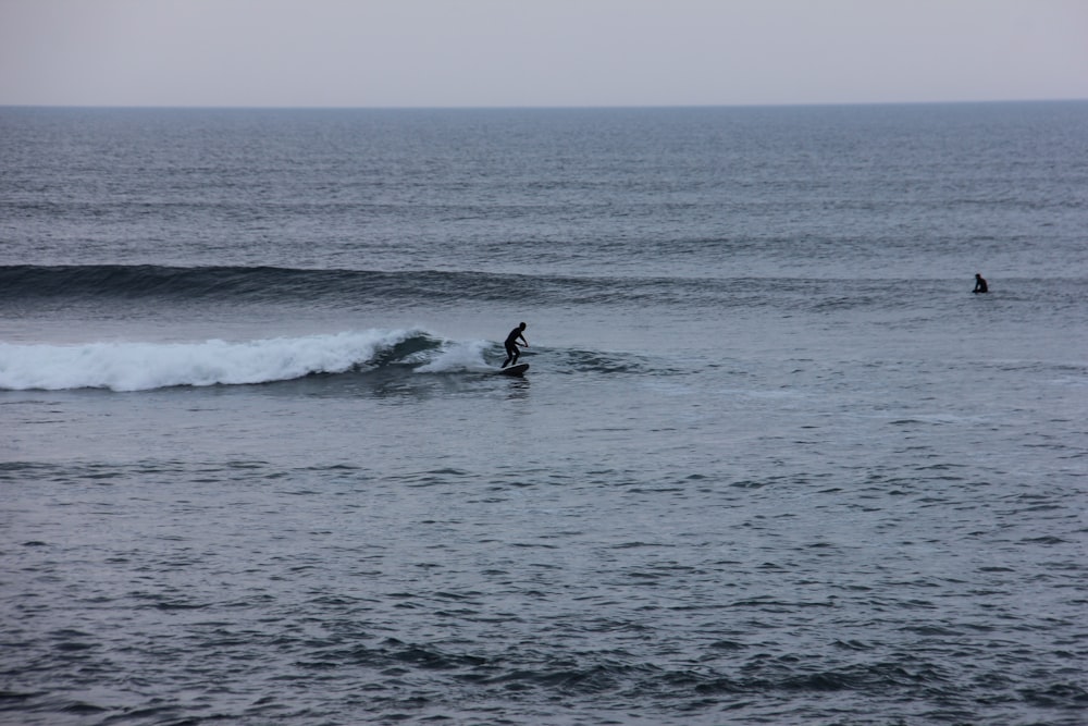 person surfing on sea waves during daytime