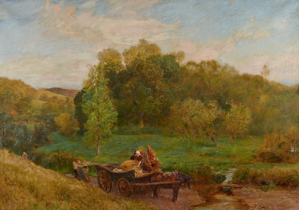 brown wooden carriage on green grass field near green trees during daytime