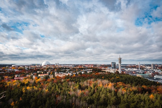 white and brown concrete building under white clouds and blue sky during daytime in Hammarby Sjöstad Sweden