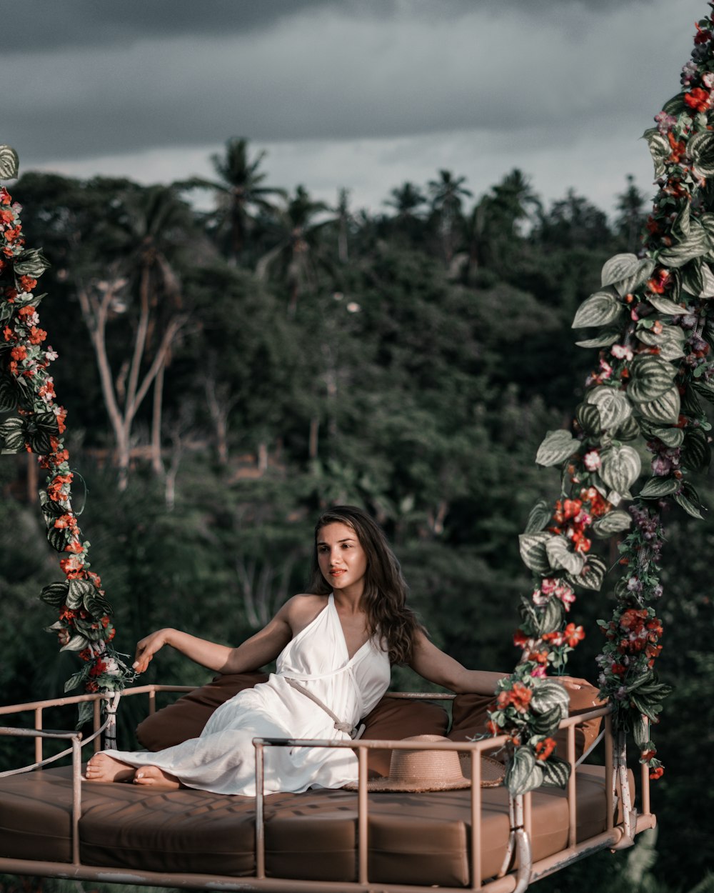 woman in white dress sitting on brown wooden bench