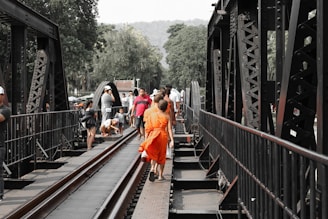 people walking on train rail during daytime