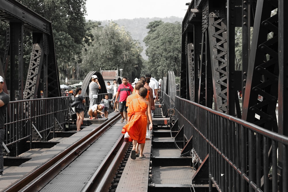 people walking on train rail during daytime
