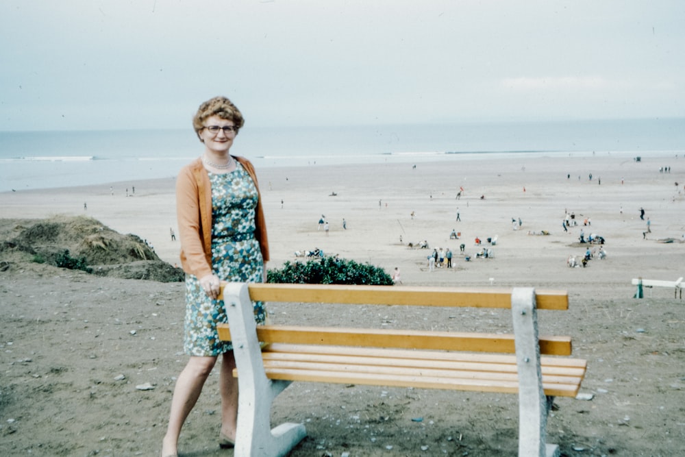 woman in blue and white floral dress sitting on brown wooden bench