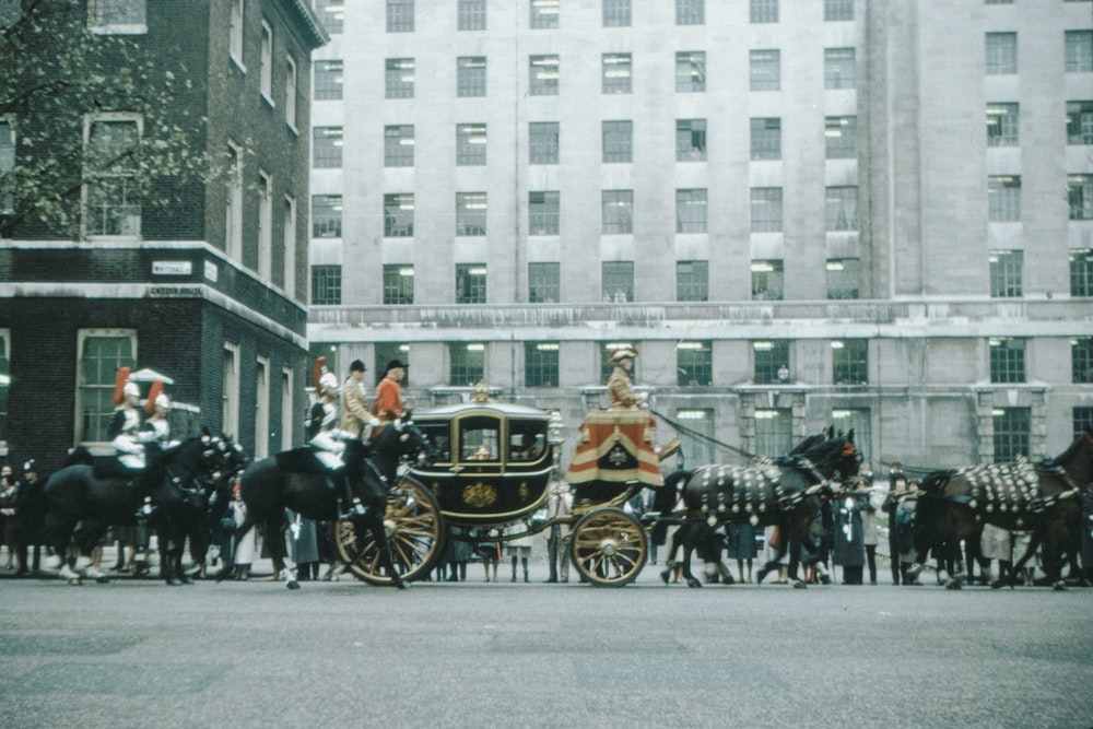 people riding on black horse carriage on road during daytime