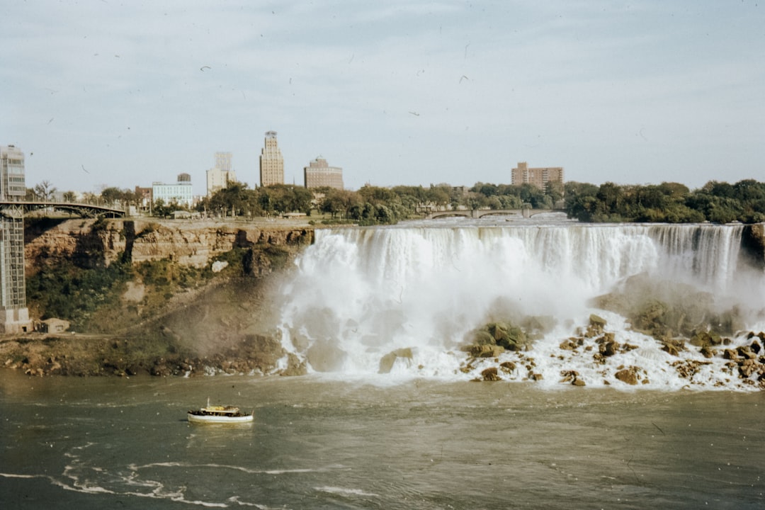 people riding on boat on water near city buildings during daytime