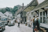 A quaint village scene with people shopping at a market.