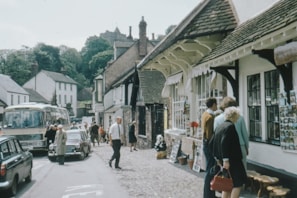 A quaint village scene with people shopping at a market.