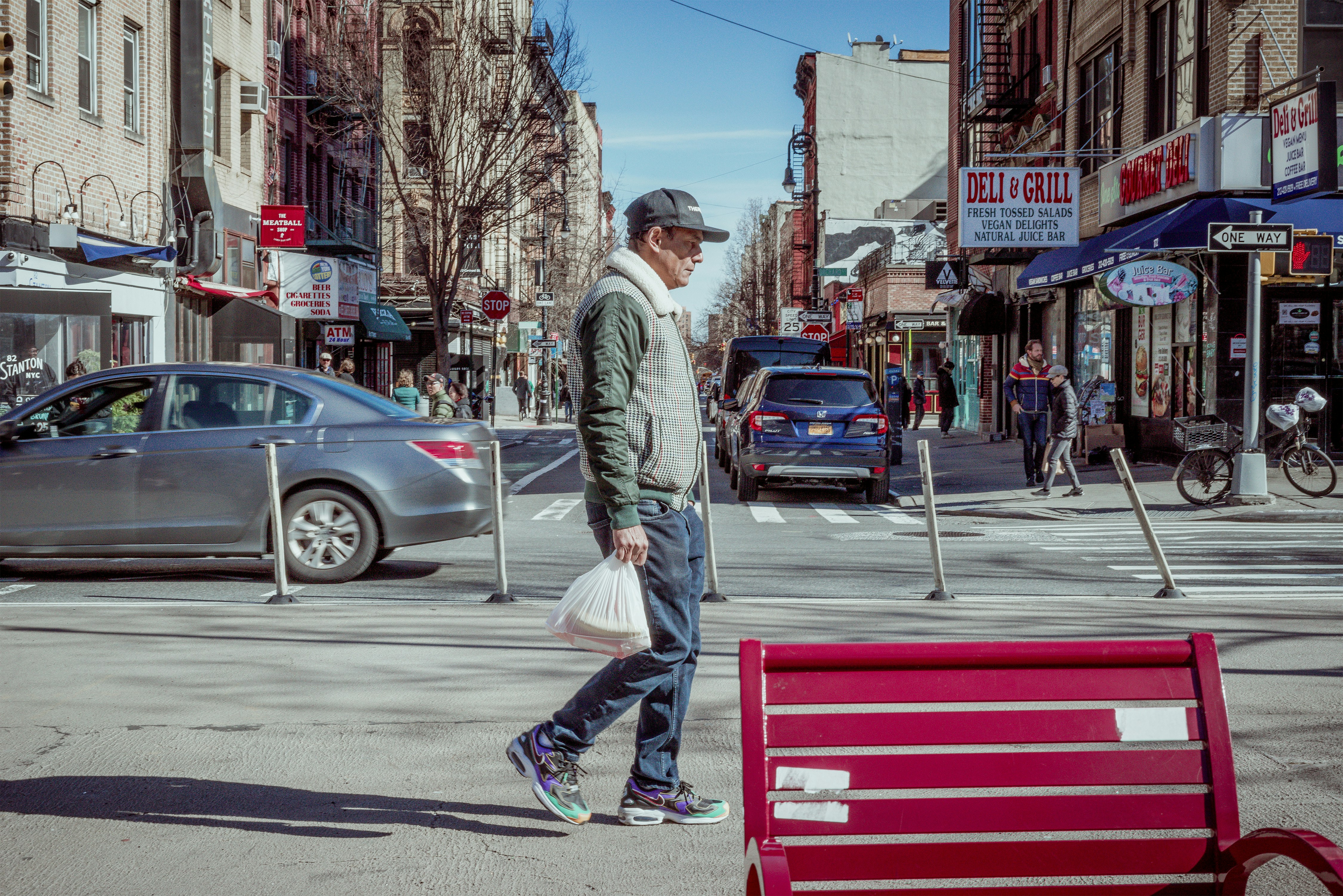 man in gray jacket and blue denim jeans walking on pedestrian lane during daytime, 