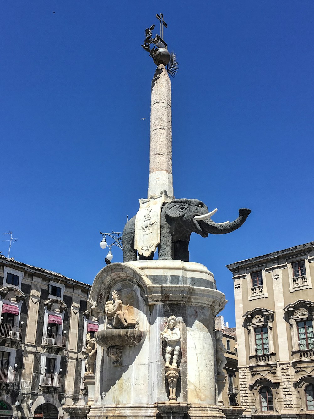 people walking on street with horse statue under blue sky during daytime