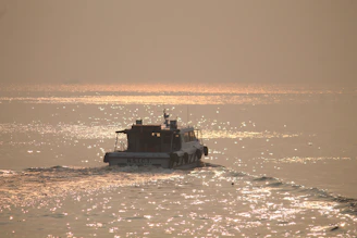 A close-up of a sleek electric boat gliding silently over calm Mediterranean waters at sunset.