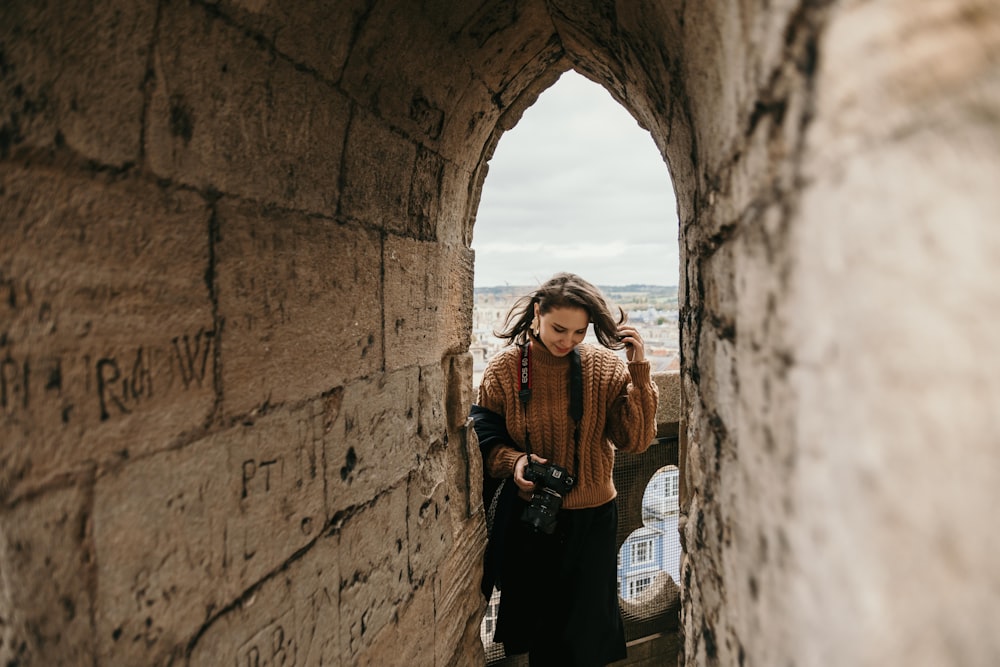 woman in black long sleeve shirt and black pants standing beside concrete wall during daytime