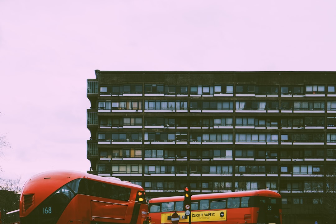 orange bus near black concrete building during daytime