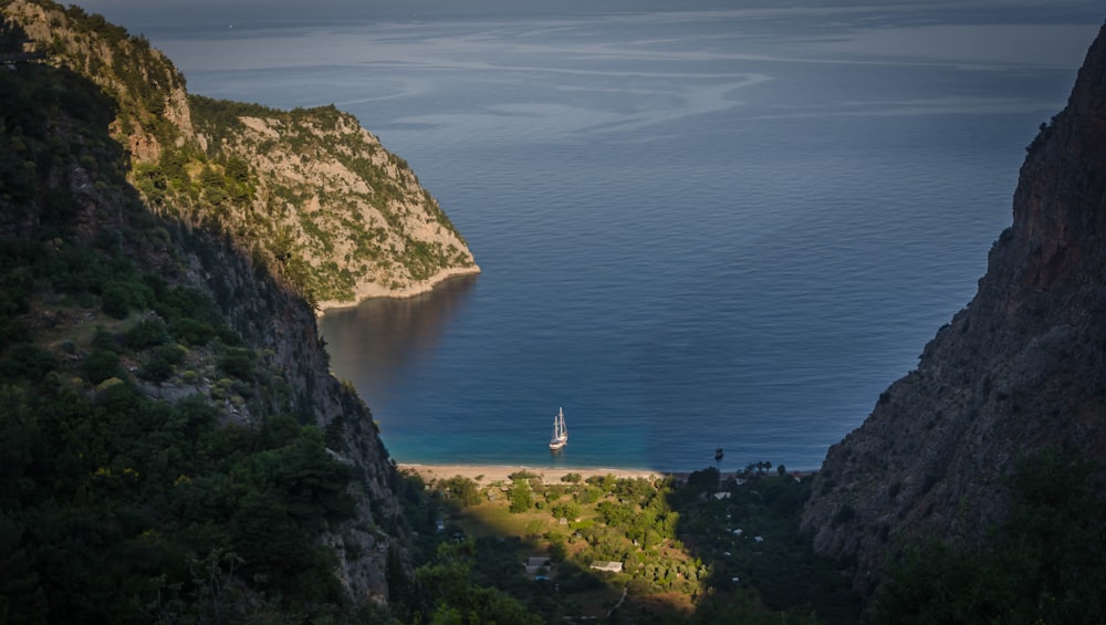 white and gray lighthouse on cliff near body of water during daytime