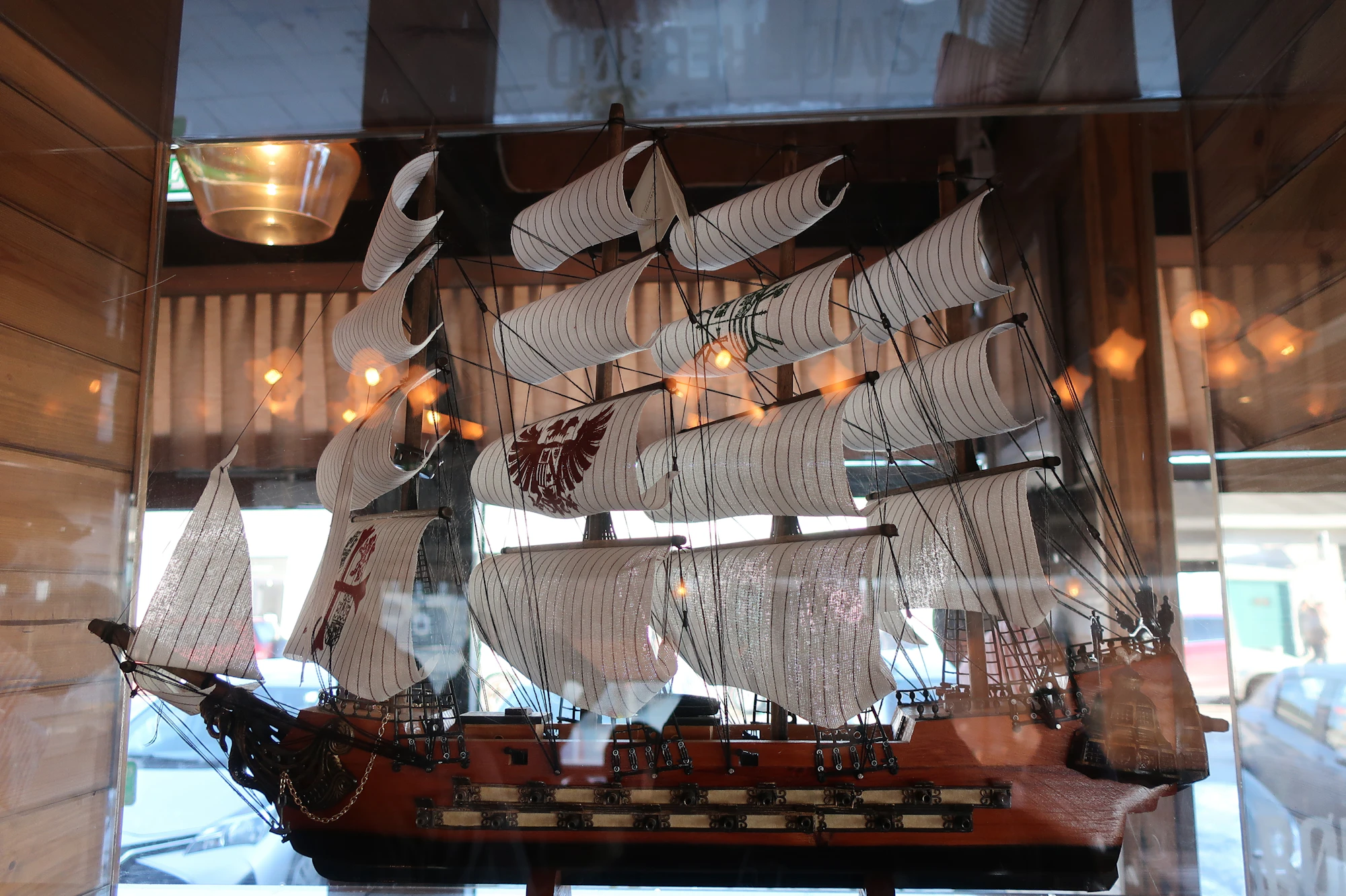 A detailed model sailing ship is displayed inside a glass museum case.