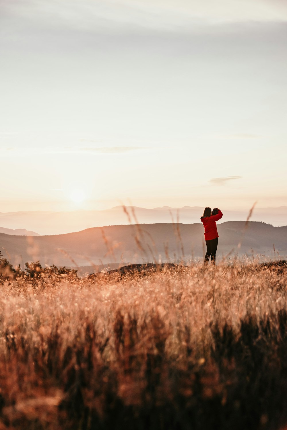 man in black jacket standing on brown grass field during daytime