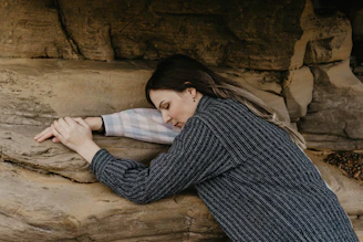 woman in black and white striped long sleeve shirt lying on brown sand