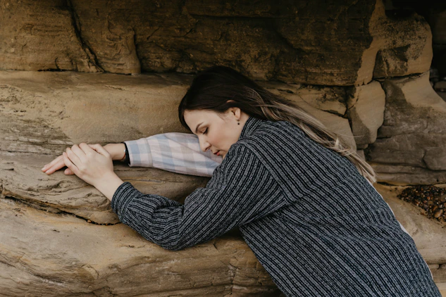 woman in black and white striped long sleeve shirt lying on brown sand
