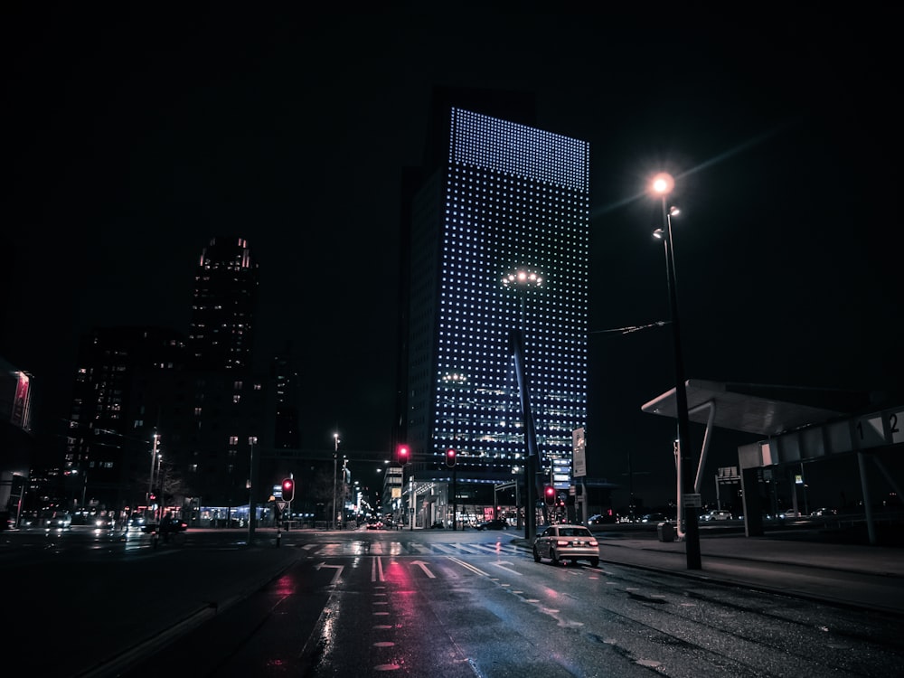 cars on road near city buildings during night time