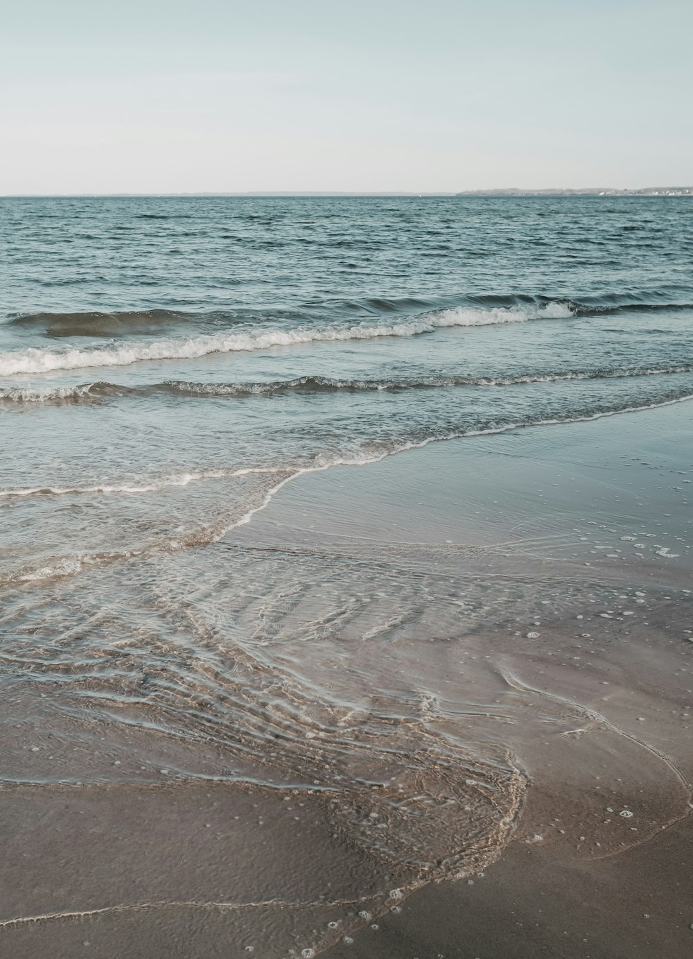 ocean waves crashing on shore during daytime