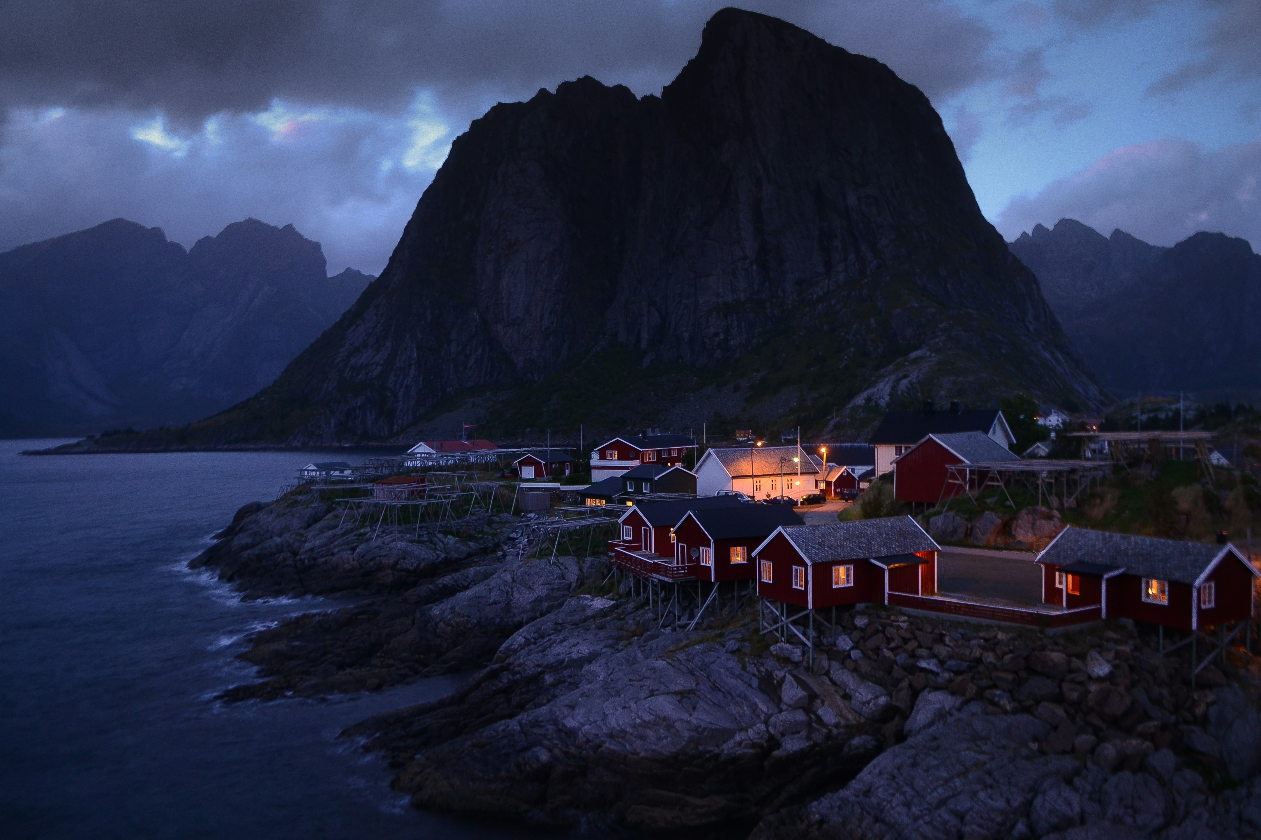 houses near body of water and mountain during daytime