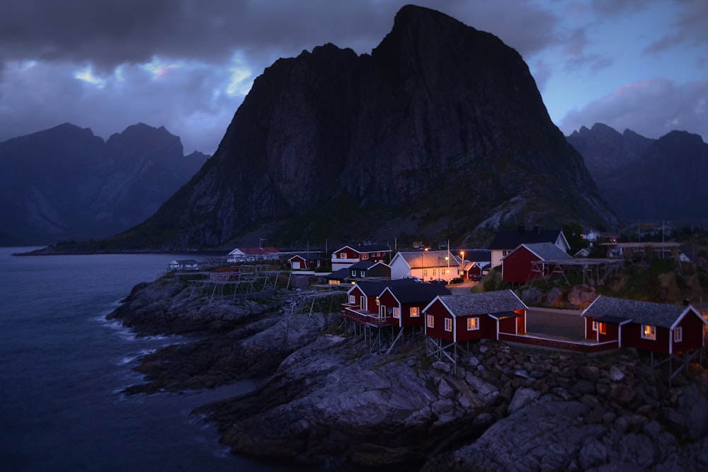 houses near body of water and mountain during daytime