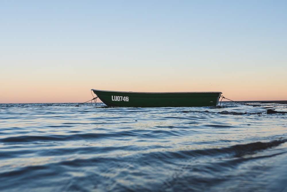 green boat on body of water during daytime