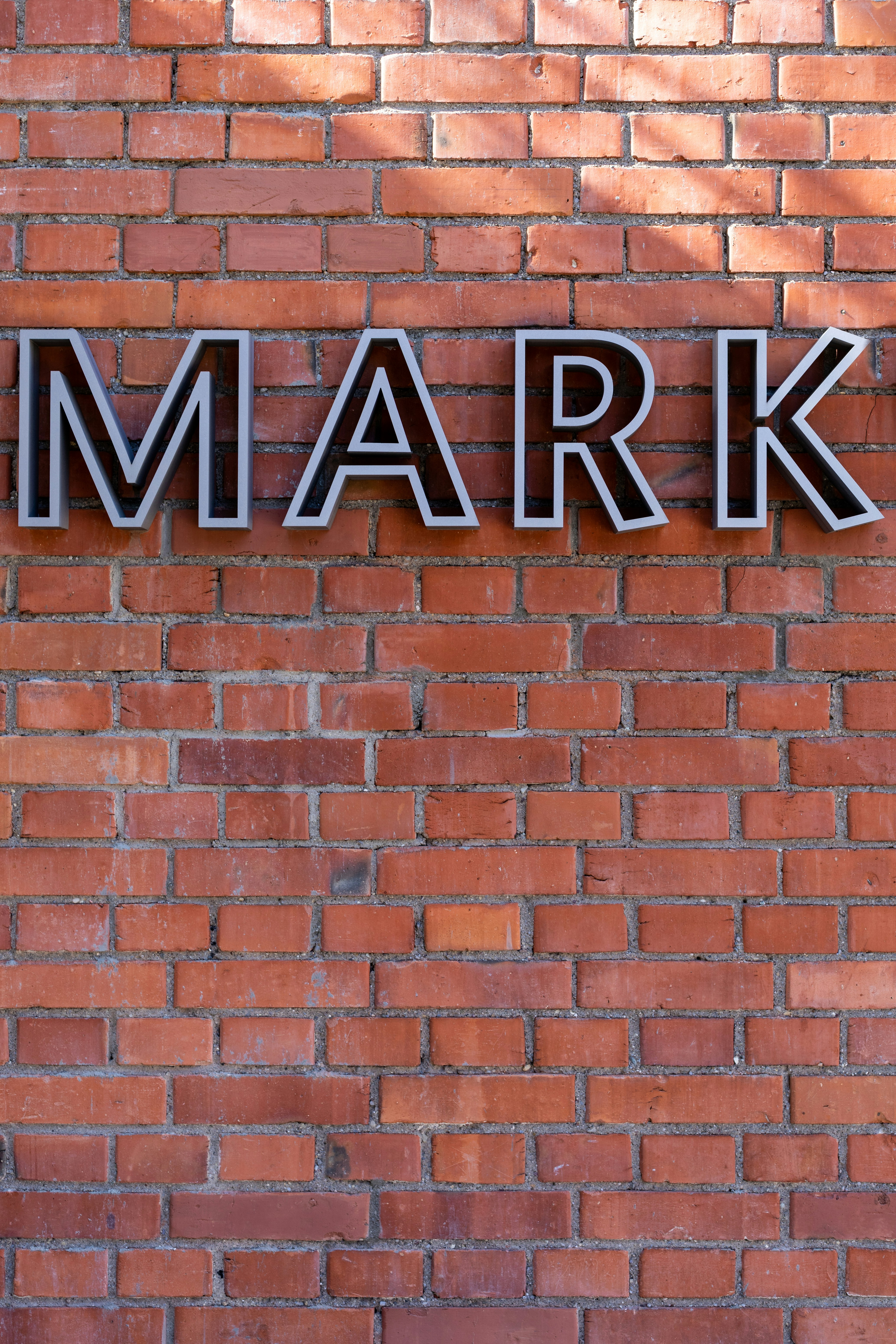 brown brick wall with black and white UNK sign