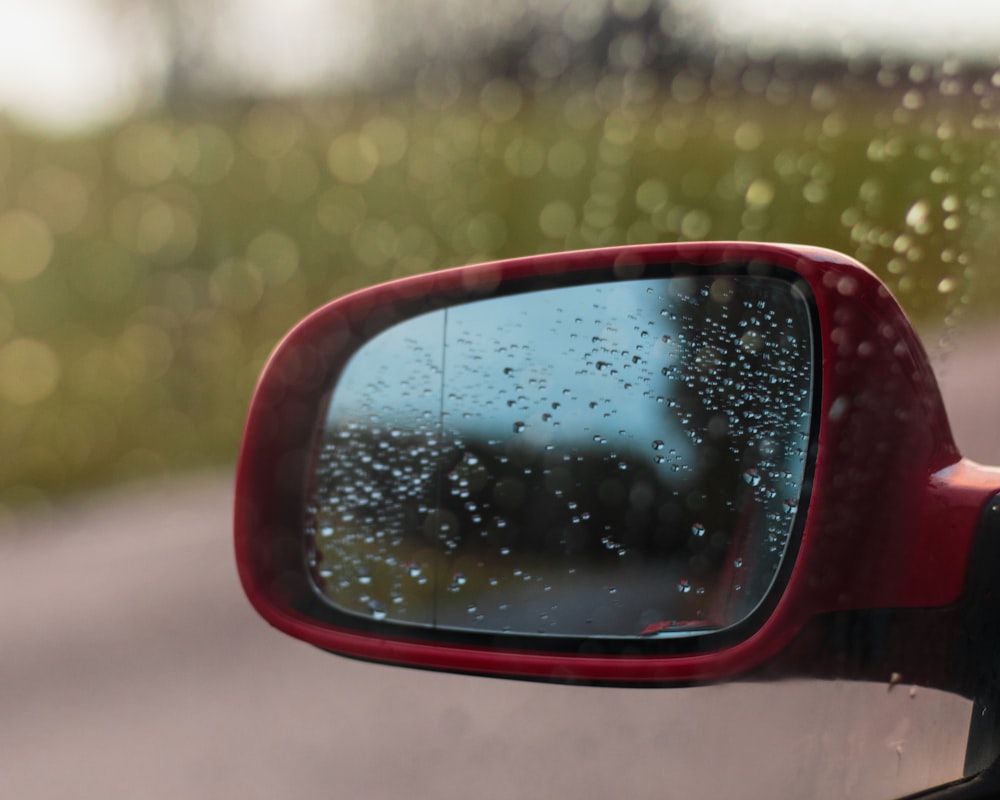 black car side mirror with water droplets