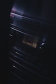 A vintage audio stereo system with a display screen showing text, illuminated in a dimly lit environment. The brand name Aiwa is visible at the top left corner, and the equipment has a sleek, reflective surface with buttons and a knob.